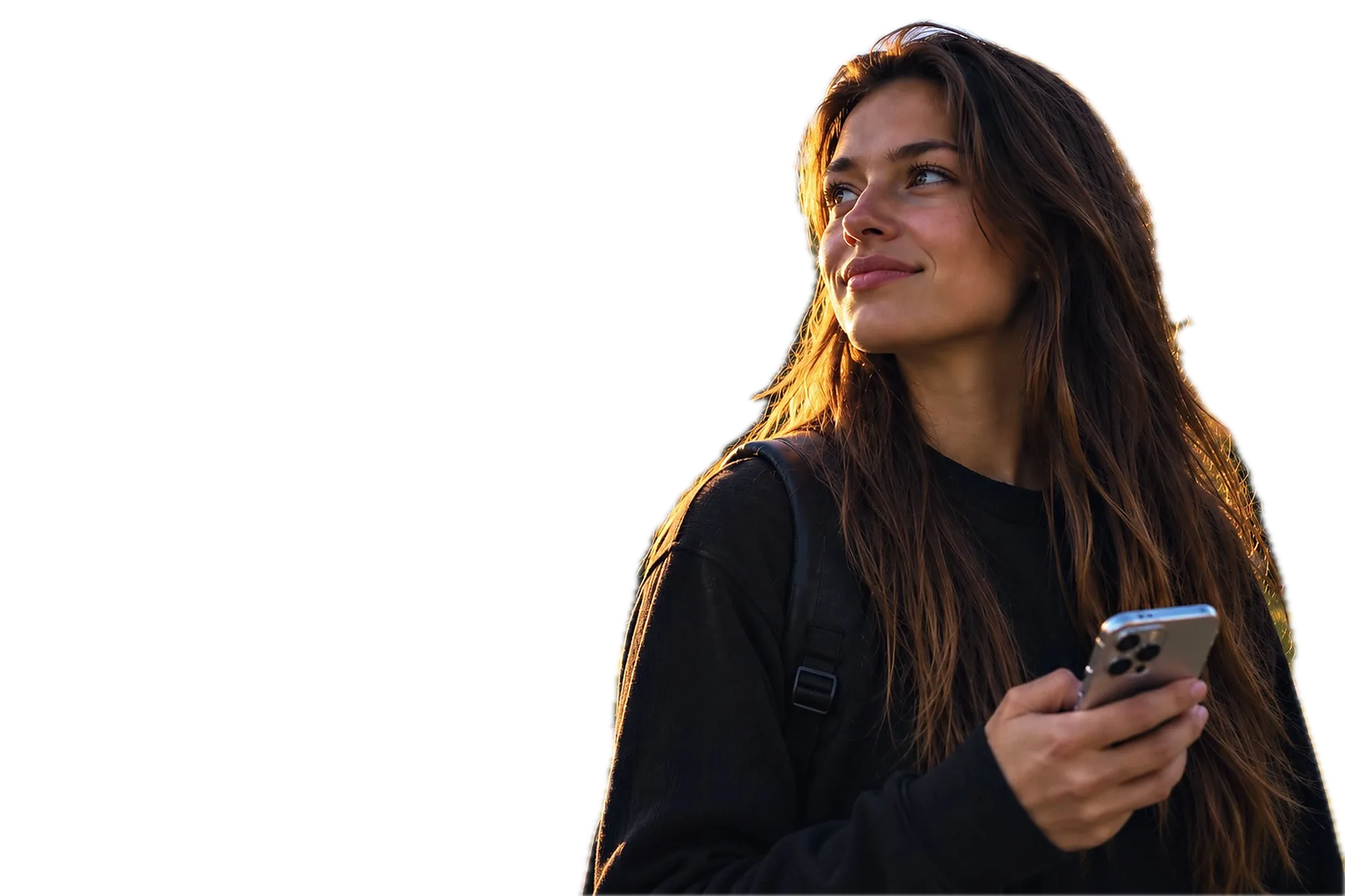 A young woman with a phone outside a church at sunset
